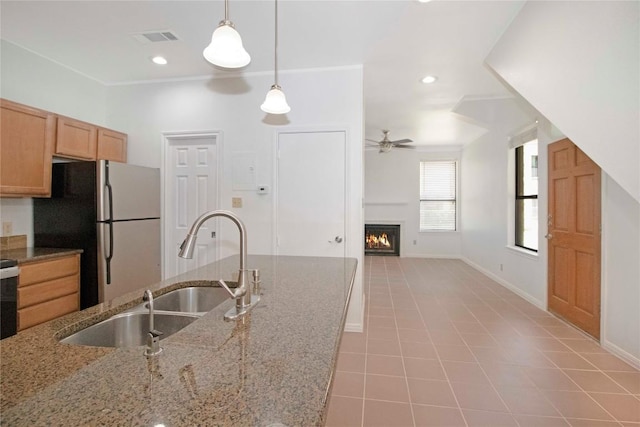 611 E 45th St Unit 8, Austin, TX 78751 - kitchen with freestanding refrigerator, ceiling fan, decorative light fixtures, a lit fireplace, and light tile patterned flooring