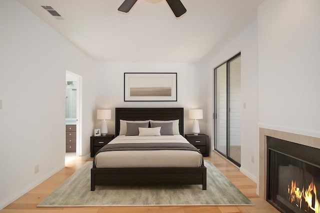 611 E 45th St Unit 8, Austin, TX 78751 - bedroom featuring light wood finished floors, a warm lit fireplace, and ceiling fan