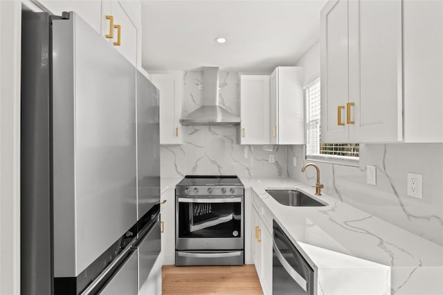 2706 Wheless Ln Unit 401, Austin, TX 78723 - kitchen with stainless steel appliances, wall chimney range hood, white cabinets, light stone counters, and backsplash