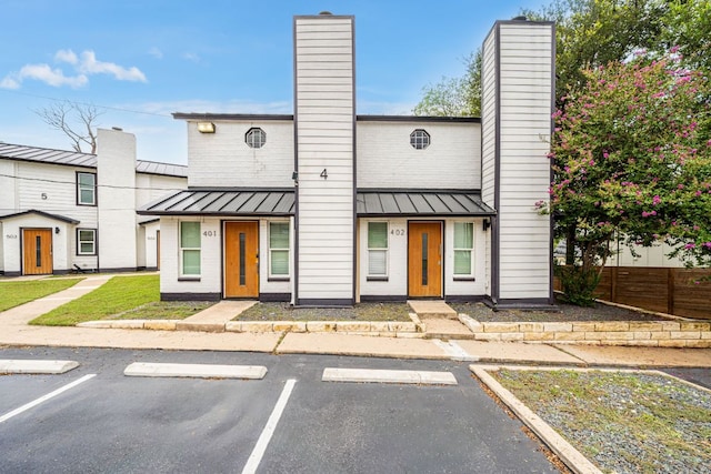 2706 Wheless Ln Unit 401, Austin, TX 78723 - view of front of property with a standing seam roof, a chimney, uncovered parking, and a metal roof