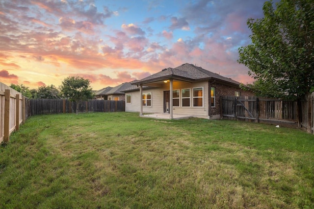 18712 Leigh Ln, Pflugerville, TX 78660 - back of property at dusk featuring a fenced backyard, a patio, and brick siding