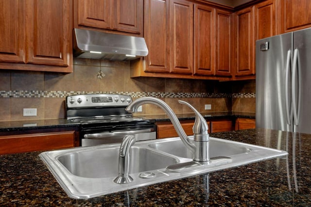 18712 Leigh Ln, Pflugerville, TX 78660 - kitchen featuring ventilation hood, stainless steel appliances, brown cabinetry, and decorative backsplash