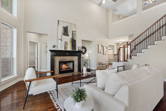 7204 Covered Bridge Dr, Austin, TX 78736 - living room featuring a ceiling fan, a high ceiling, stairs, wood finished floors, and a lit fireplace