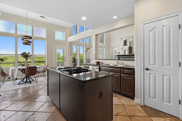 7204 Covered Bridge Dr, Austin, TX 78736 - kitchen with stone tile floors, stainless steel appliances, a kitchen island, healthy amount of natural light, and recessed lighting