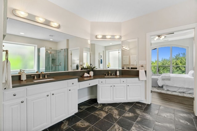 7204 Covered Bridge Dr, Austin, TX 78736 - ensuite bathroom with double vanity, plenty of natural light, a stall shower, and ceiling fan