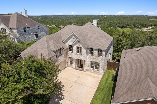 7204 Covered Bridge Dr, Austin, TX 78736 - french country inspired facade with stone siding, a chimney, a patio area, and concrete driveway