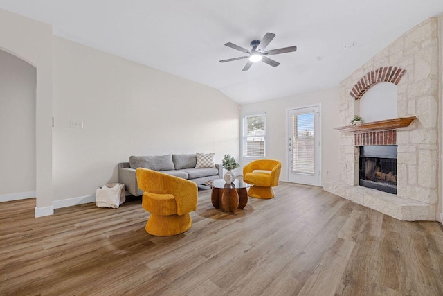 608 Timothy John Dr, Pflugerville, TX 78660 - living area featuring wood finished floors, arched walkways, ceiling fan, a stone fireplace, and vaulted ceiling