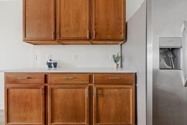 608 Timothy John Dr, Pflugerville, TX 78660 - kitchen with stainless steel fridge with ice dispenser, light countertops, and brown cabinetry