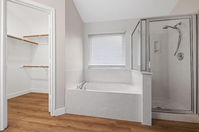 608 Timothy John Dr, Pflugerville, TX 78660 - full bath featuring vaulted ceiling, a stall shower, a garden tub, a spacious closet, and wood finished floors