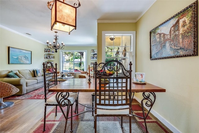 1506 Alguno Rd, Austin, TX 78757 - dining area featuring wood finished floors, ornamental molding, and a chandelier