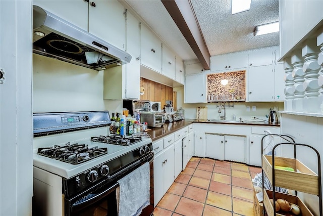 1506 Alguno Rd, Austin, TX 78757 - kitchen featuring gas stove, exhaust hood, white cabinets, and a textured ceiling