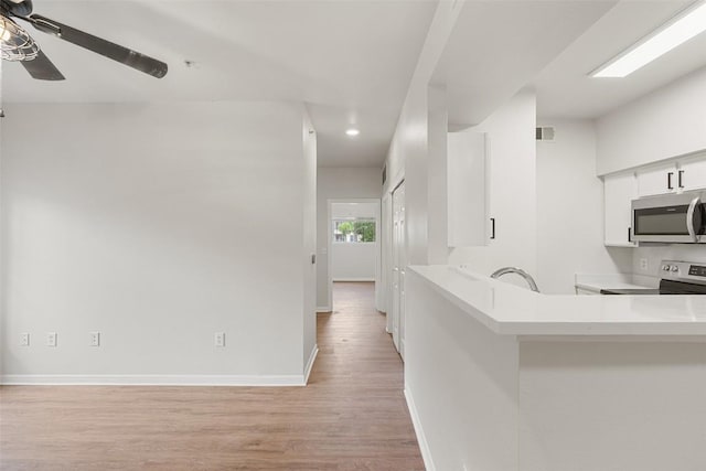 2320 Gracy Farms Ln Unit 323, Austin, TX 78758 - kitchen featuring stainless steel appliances, light countertops, white cabinetry, light wood-type flooring, and recessed lighting