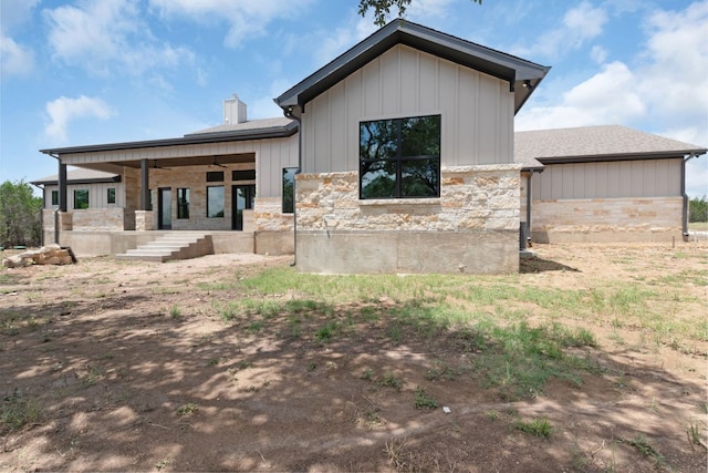 209 Burnet Oaks Dr, Burnet, TX 78611 - back of house with stone siding, board and batten siding, a chimney, and a shingled roof