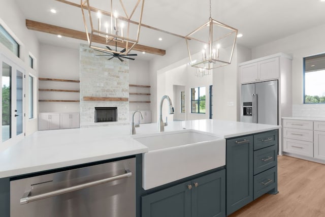 209 Burnet Oaks Dr, Burnet, TX 78611 - kitchen featuring a chandelier, appliances with stainless steel finishes, open floor plan, beamed ceiling, and light wood-style flooring