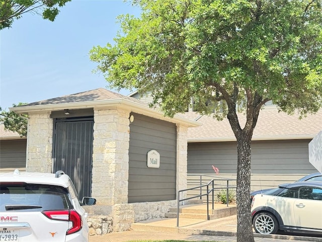2320 Gracy Farms Ln Unit 1432, Austin, TX 78758 - view of front of house with a shingled roof and stone siding