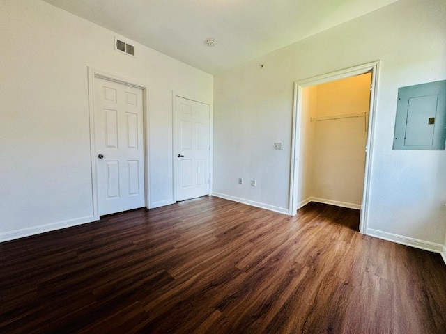 2320 Gracy Farms Ln Unit 1432, Austin, TX 78758 - unfurnished bedroom with electric panel, dark wood finished floors, and a walk in closet