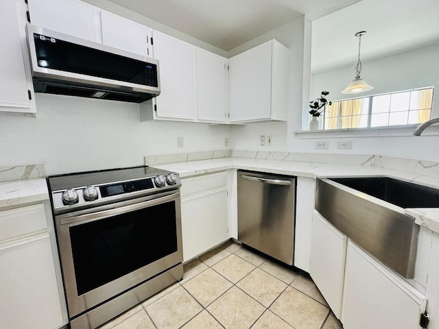 2320 Gracy Farms Ln Unit 1432, Austin, TX 78758 - kitchen with appliances with stainless steel finishes, white cabinetry, light tile patterned floors, and light stone counters