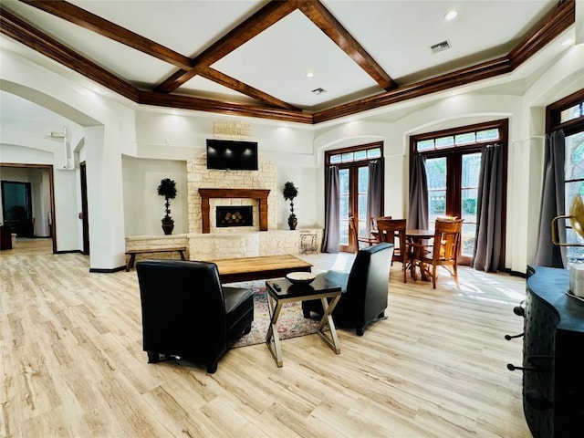2320 Gracy Farms Ln Unit 1432, Austin, TX 78758 - living area featuring french doors, light wood-style floors, beamed ceiling, a fireplace, and ornamental molding