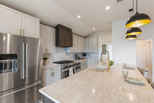 18924 Peckham Dr, Point Venture, TX 78645 - kitchen featuring premium appliances, backsplash, vaulted ceiling, light stone counters, and pendant lighting