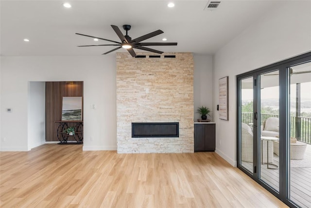 18924 Peckham Dr, Point Venture, TX 78645 - unfurnished living room with a ceiling fan, wood finished floors, a stone fireplace, recessed lighting, and a towering ceiling