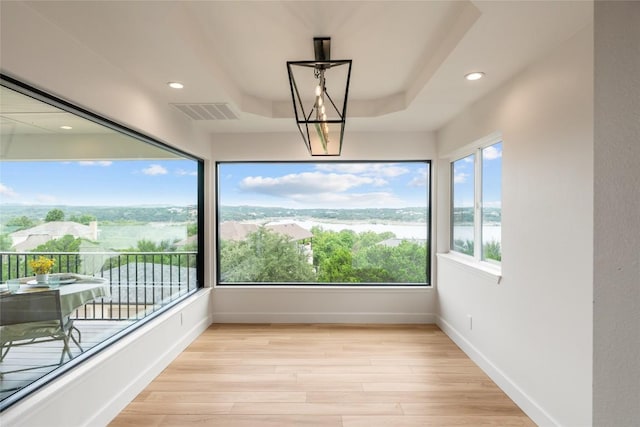 18924 Peckham Dr, Point Venture, TX 78645 - unfurnished sunroom featuring wood finished floors, recessed lighting, a water view, and a tray ceiling