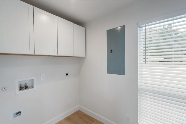 18924 Peckham Dr, Point Venture, TX 78645 - laundry area with electric panel, cabinet space, electric dryer hookup, hookup for a washing machine, and light wood-style flooring