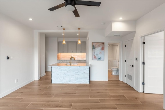 18924 Peckham Dr, Point Venture, TX 78645 - kitchen with ceiling fan, light countertops, decorative backsplash, light wood-style floors, and recessed lighting
