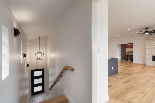 18924 Peckham Dr, Point Venture, TX 78645 - entrance foyer with a ceiling fan, light wood-type flooring, a fireplace, recessed lighting, and a chandelier