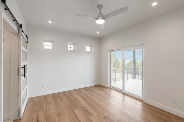 18924 Peckham Dr, Point Venture, TX 78645 - unfurnished room with a barn door, a ceiling fan, light wood-style floors, and recessed lighting