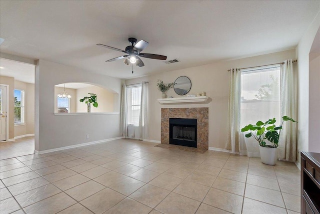 327 Lakemont Dr, Hutto, TX 78634 - unfurnished living room featuring light tile patterned floors, a premium fireplace, ceiling fan, and plenty of natural light