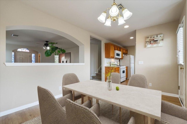 327 Lakemont Dr, Hutto, TX 78634 - dining room featuring light wood finished floors, stairway, ceiling fan, recessed lighting, and a chandelier