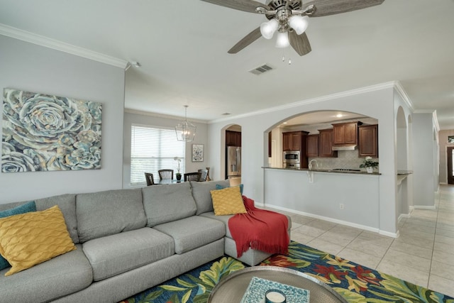 12421 Black Hills Dr, Austin, TX 78748 - living room with crown molding, light tile patterned flooring, ceiling fan, arched walkways, and a chandelier