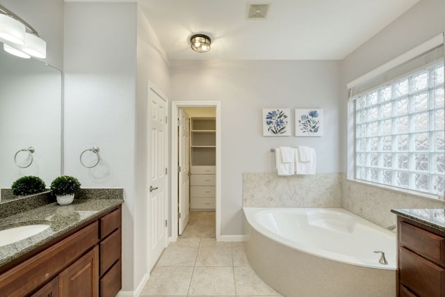 12421 Black Hills Dr, Austin, TX 78748 - bathroom with vanity, a bath, tile patterned floors, and a spacious closet