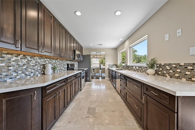2512 Regal Park Ln, Austin, TX 78748 - kitchen with stainless steel appliances, light countertops, dark brown cabinets, and recessed lighting