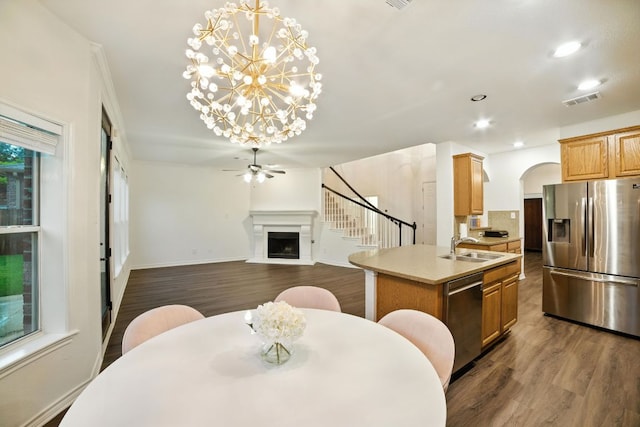 3801 Poppy Hills Cv, Round Rock, TX 78664 - dining area with dark wood-style flooring, arched walkways, a fireplace, recessed lighting, and a chandelier