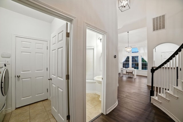 3801 Poppy Hills Cv, Round Rock, TX 78664 - washroom with washer / dryer, a chandelier, wood finished floors, and a towering ceiling