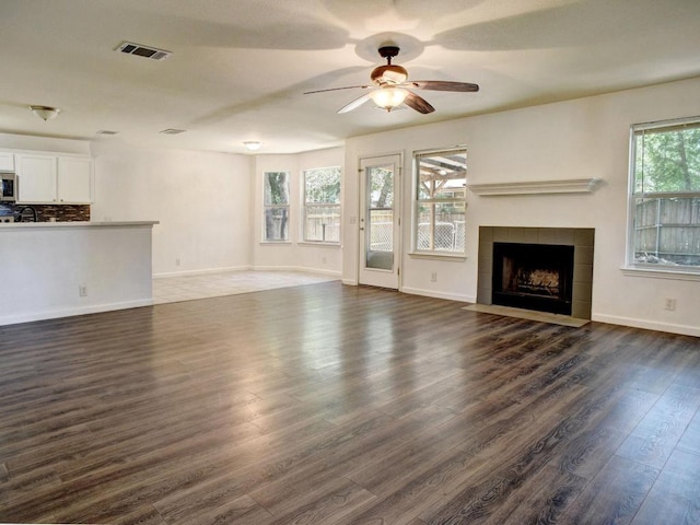 117 High Point Blvd, Cedar Creek, TX 78612 - unfurnished living room featuring dark wood-style floors, ceiling fan, and a fireplace