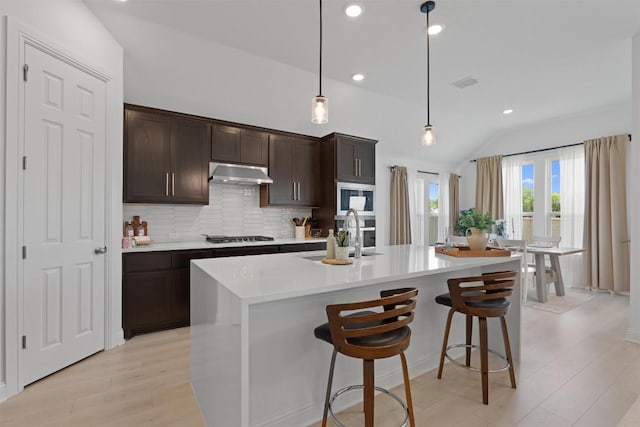 20240 Smedley Dr, Pflugerville, TX 78660 - kitchen with under cabinet range hood, light countertops, decorative backsplash, dark brown cabinetry, and recessed lighting