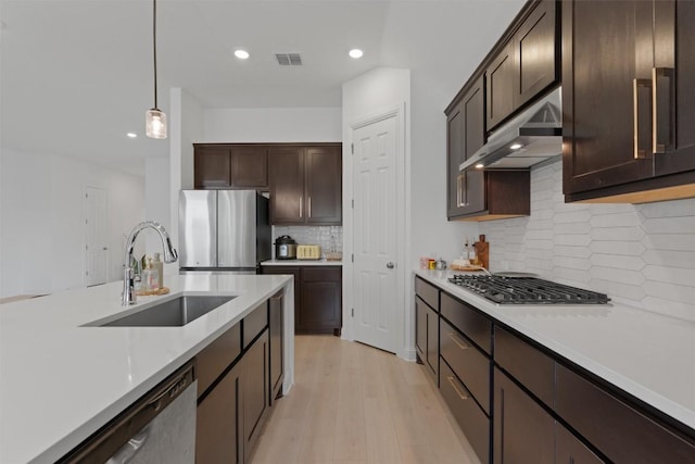 20240 Smedley Dr, Pflugerville, TX 78660 - kitchen with stainless steel appliances, under cabinet range hood, recessed lighting, dark brown cabinets, and light countertops
