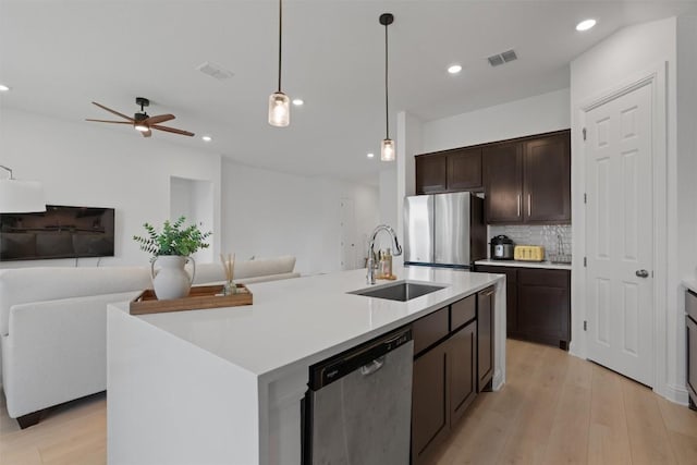 20240 Smedley Dr, Pflugerville, TX 78660 - kitchen featuring stainless steel appliances, dark brown cabinets, decorative backsplash, open floor plan, and recessed lighting