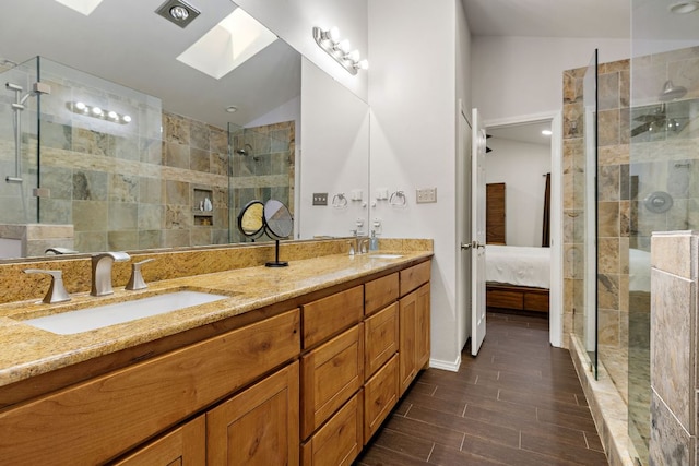 15002 Wells Port Dr, Austin, TX 78728 - ensuite bathroom with a skylight, double vanity, a tile shower, wood finished floors, and vaulted ceiling