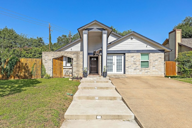 15002 Wells Port Dr, Austin, TX 78728 - view of front of home with french doors, brick siding, and concrete driveway