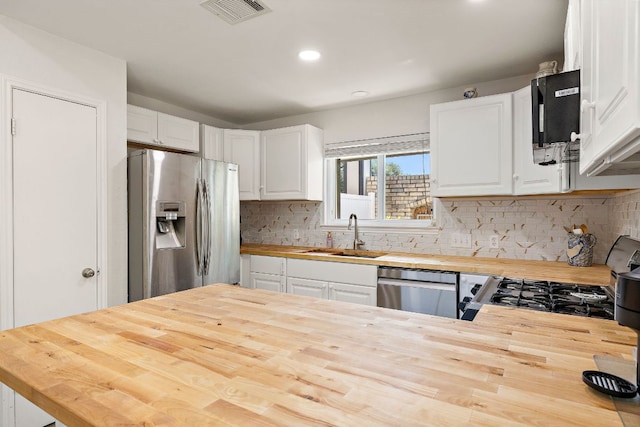 15002 Wells Port Dr, Austin, TX 78728 - kitchen featuring butcher block counters, stainless steel appliances, white cabinetry, tasteful backsplash, and recessed lighting