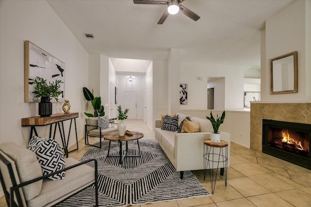 3413 Latimer Dr, Austin, TX 78732 - living room with a ceiling fan, a textured ceiling, a tiled fireplace, and light tile patterned floors