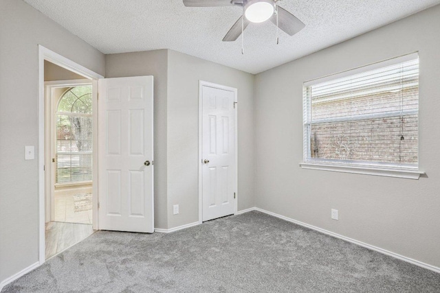 17003 Jigsaw Pathway, Round Rock, TX 78664 - unfurnished bedroom featuring carpet floors, multiple windows, a textured ceiling, and ceiling fan