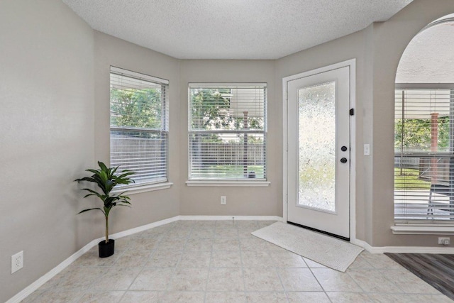 17003 Jigsaw Pathway, Round Rock, TX 78664 - entryway with plenty of natural light, a textured ceiling, arched walkways, and tile patterned floors
