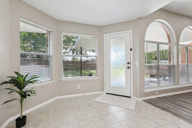 17003 Jigsaw Pathway, Round Rock, TX 78664 - tiled foyer featuring a textured ceiling and baseboards