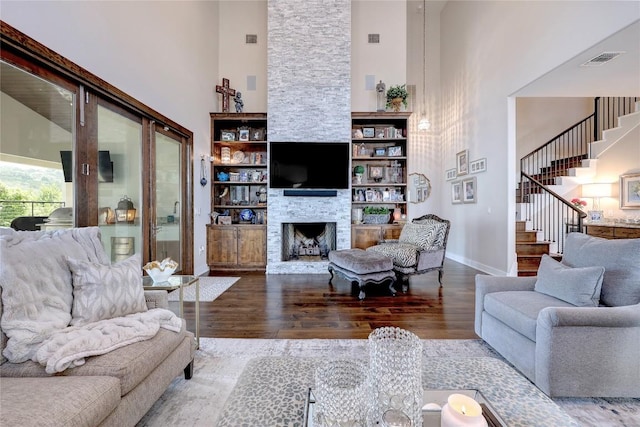 3973 River Place Blvd, Austin, TX 78730 - living area featuring a towering ceiling, wood finished floors, stairway, and a stone fireplace