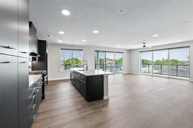 4510 Terry-O Ln Unit 230, Austin, TX 78745 - kitchen with dark cabinets, light countertops, recessed lighting, wood finished floors, and an island with sink