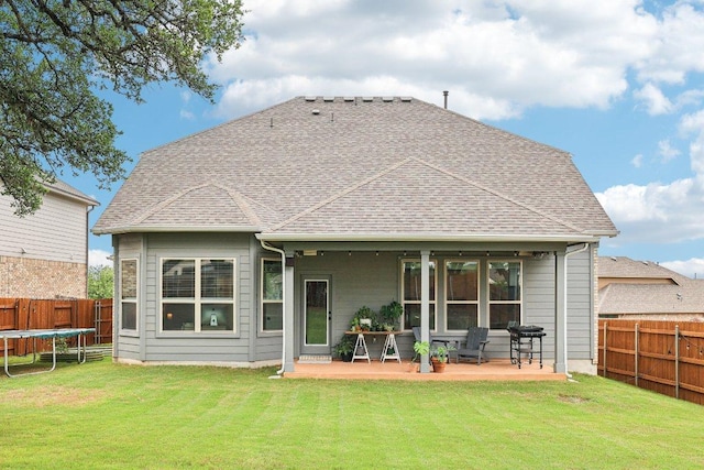 958 Pink Granite Blvd, Dripping Springs, TX 78620 - rear view of house featuring a trampoline, a fenced backyard, a patio, and a shingled roof